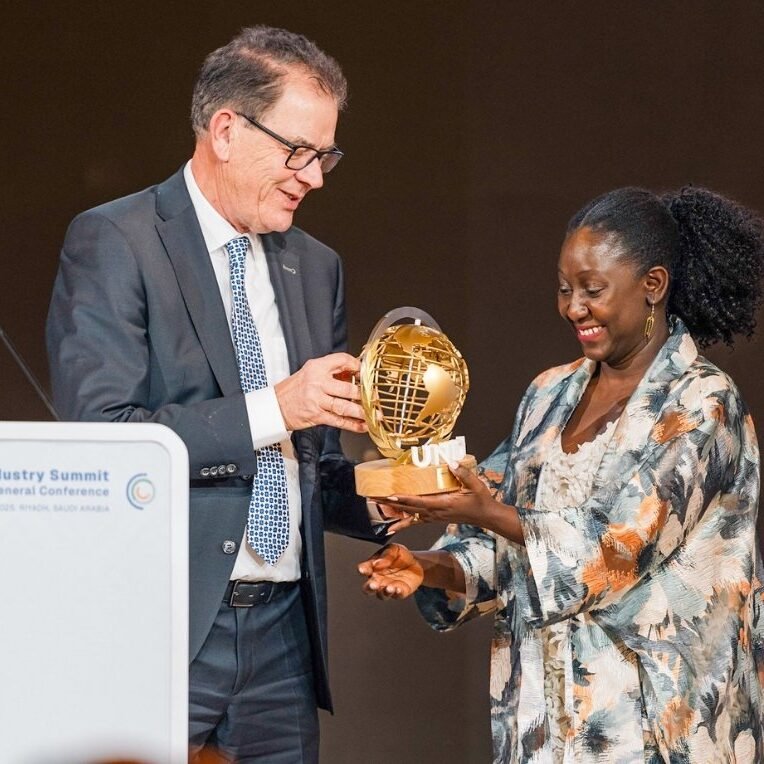 UNIDO – One World Sustainability Award 2 Man at podium awarding woman employee with a trophy