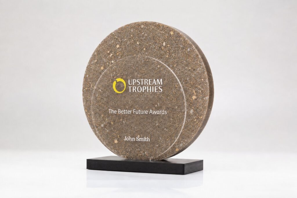 Round Eclipse trophy with Gold Dust centerpiece made from recycled perfume caps on a black base